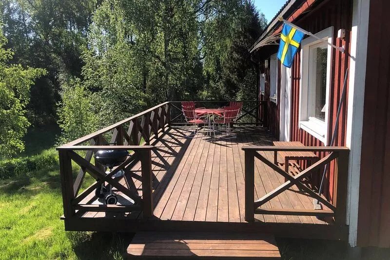 Nice red-white cottage by the lake with a boat