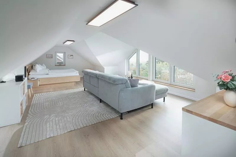 In the spacious living area on the second floor, you will find a cozy sofa, a