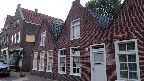 Banpaal in de vorm van een natuurstenen obelisk op bakstenen voet