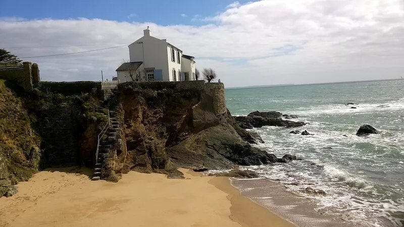 House on rocky promontory facing the sea. Private beach access