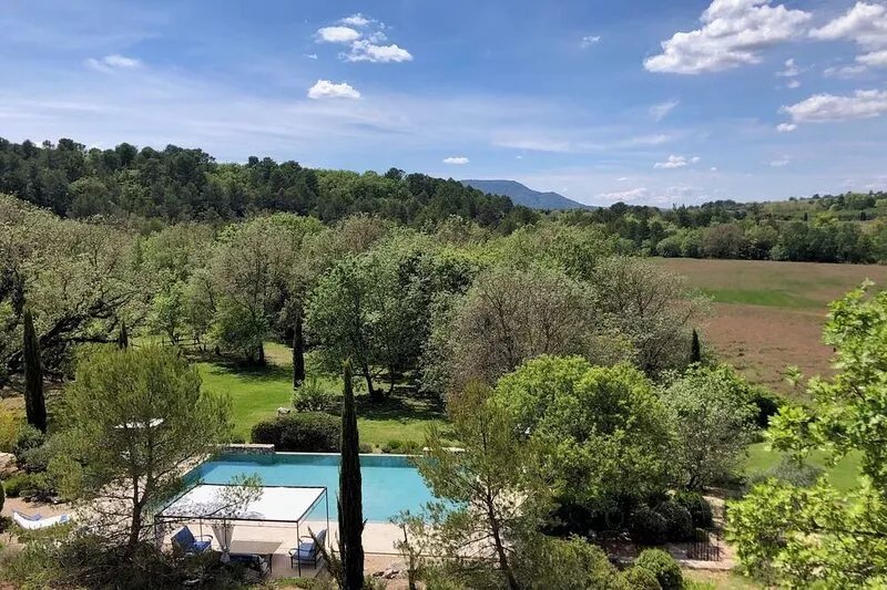 Stone farmhouse with swimming pool surrounded by nature, panoramic view