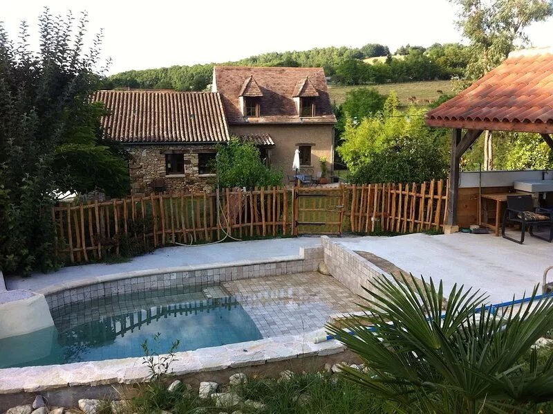 A perigordian house with a beautiful garden and a swimming pool.
