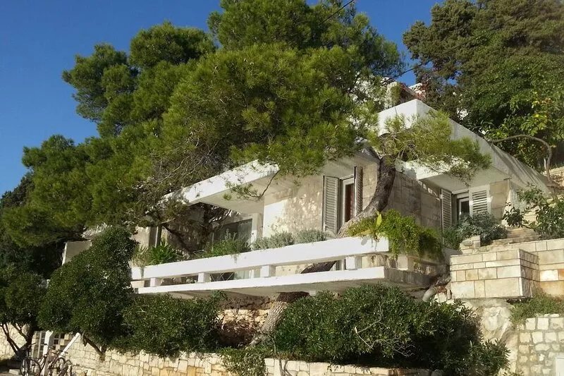 Maison d'architecte avec grandes terrasses ombragées en front de mer.