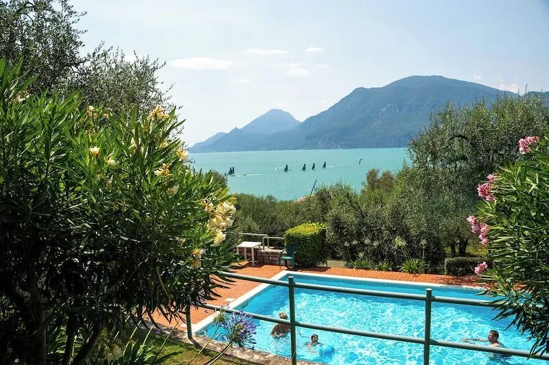 Wonderful balcony on the lake with beautiful pool and garden among palm and
