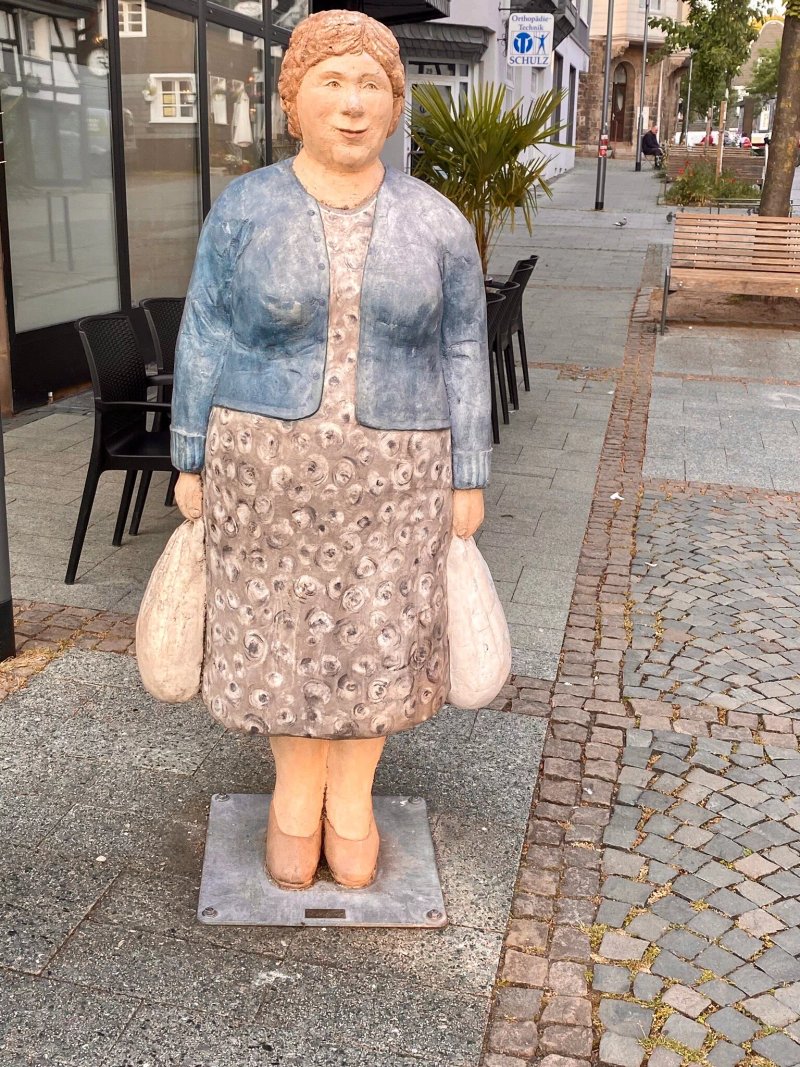 Skulpturen einer einkaufenden Frau und eines fotografierenden Mannes