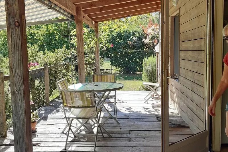Small detached wooden house in well-maintained fenced park.