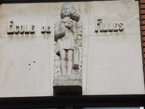 Haut-relief signalant de l'entree des filles representant une ecoliere