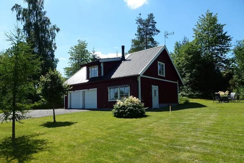 House With An Unique Gathering Of Hunting Trophies. View Of The Pond & Village